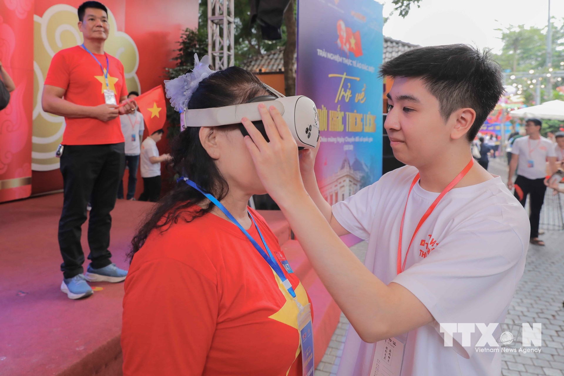 Nhân viên hướng dẫn người dân sử dụng kính thực tế ảo (VR), đưa công nghệ đến gần hơn với công chúng. (Ảnh: Phan Phương/TTXVN)